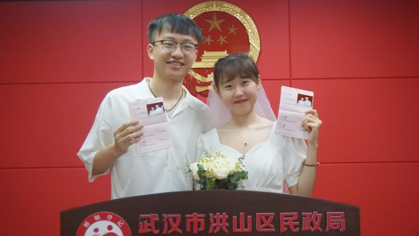 谭增栋和张宇婷在洪山区民政局领结婚证.谭增栋提供