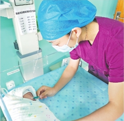 武汉市妇幼保健院助产士万美玲在给新生宝宝吸氧.
