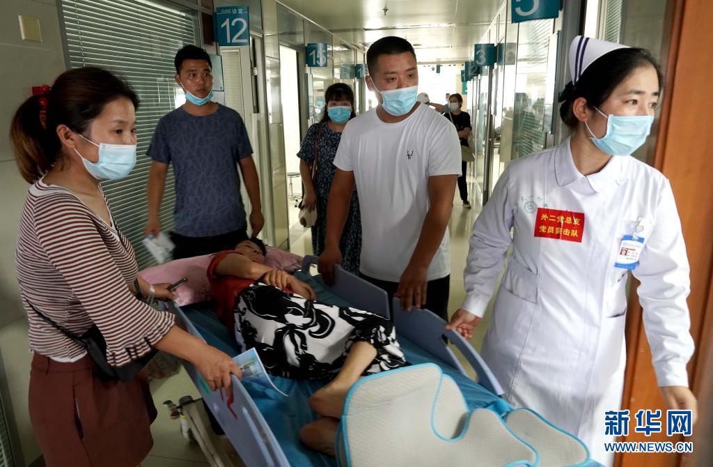 7月26日,医生在郑大一附院河医院区转移患者.新华社记者 李安 摄