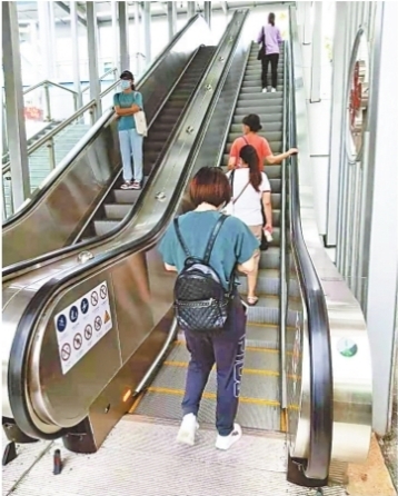 同济健康天桥电梯开通运行,市民乘手扶电梯过街.记者李爱华 摄