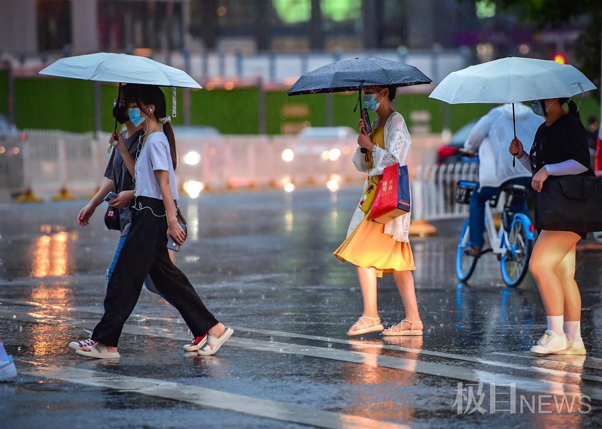 武昌汉街上的行人打起雨伞,匆匆走过.