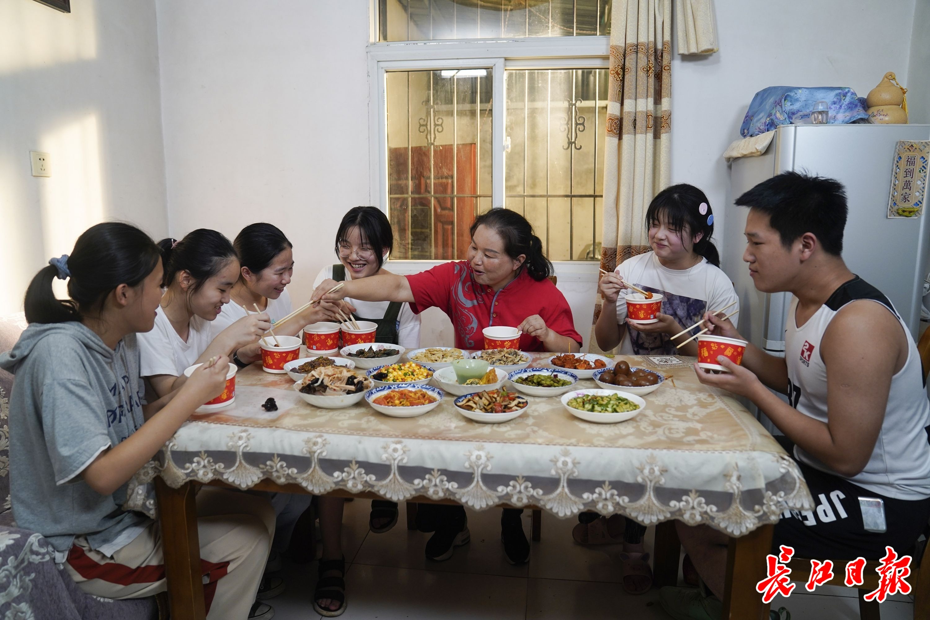 8月29日,郑铭(左五)邀请同学们来家里吃饭,他们像一家人一样边吃饭边