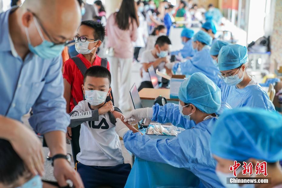 南宁市天桃实验学校天桃校区,小学生在家长陪同下接种新冠疫苗