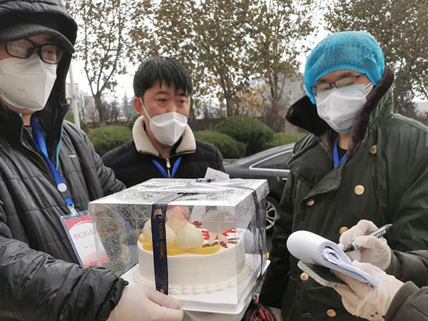 图为旅顺口区政法干警志愿者细心护送生日蛋糕.