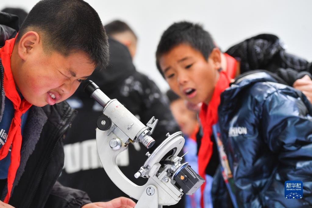 1月19日,在湖南省浏阳市小河乡的星河天文台,学生通过显微镜观看陨石