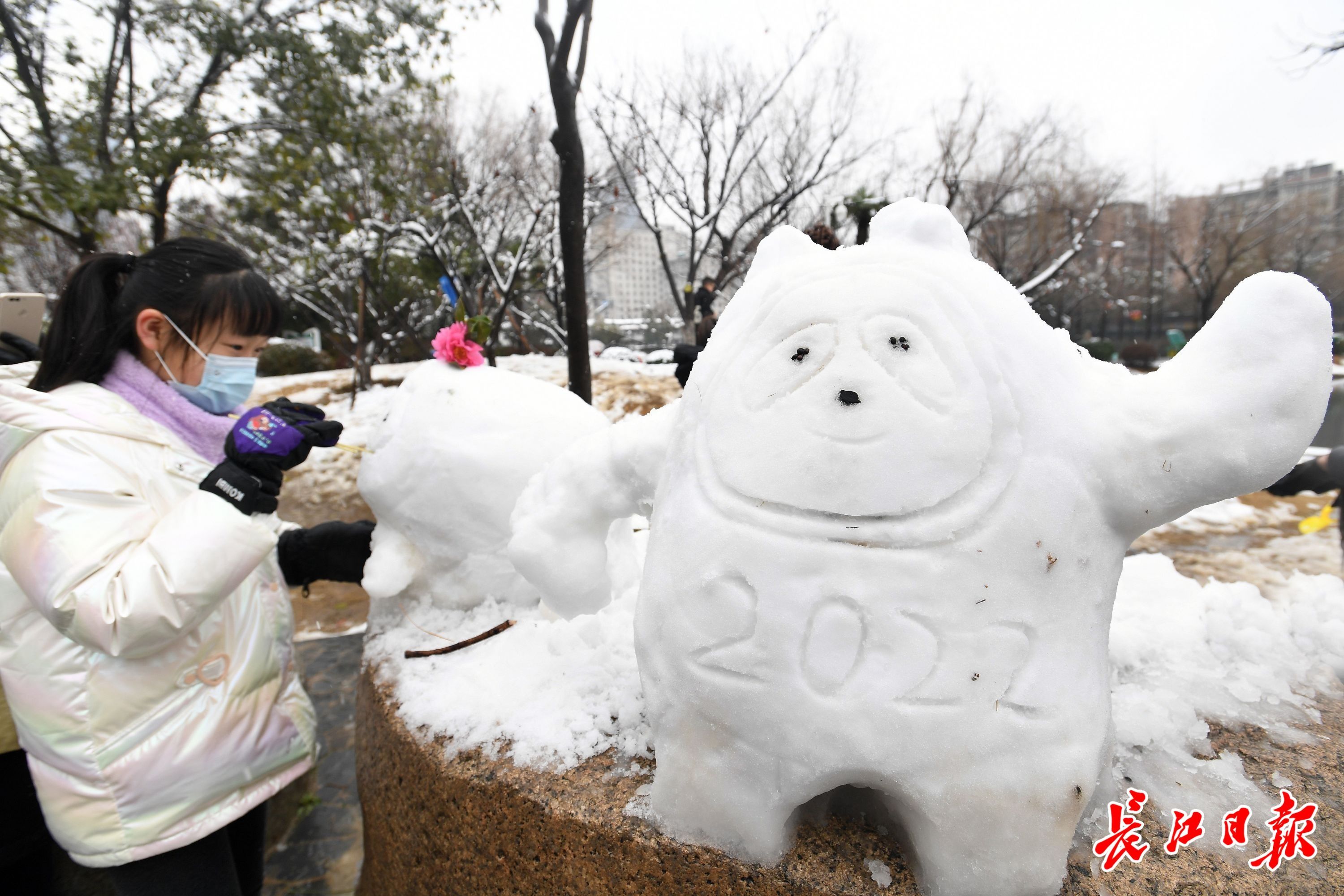 宝岛公园湖心岛上,不少家长陪着孩子堆着各式各样的雪人,图为冰墩墩.