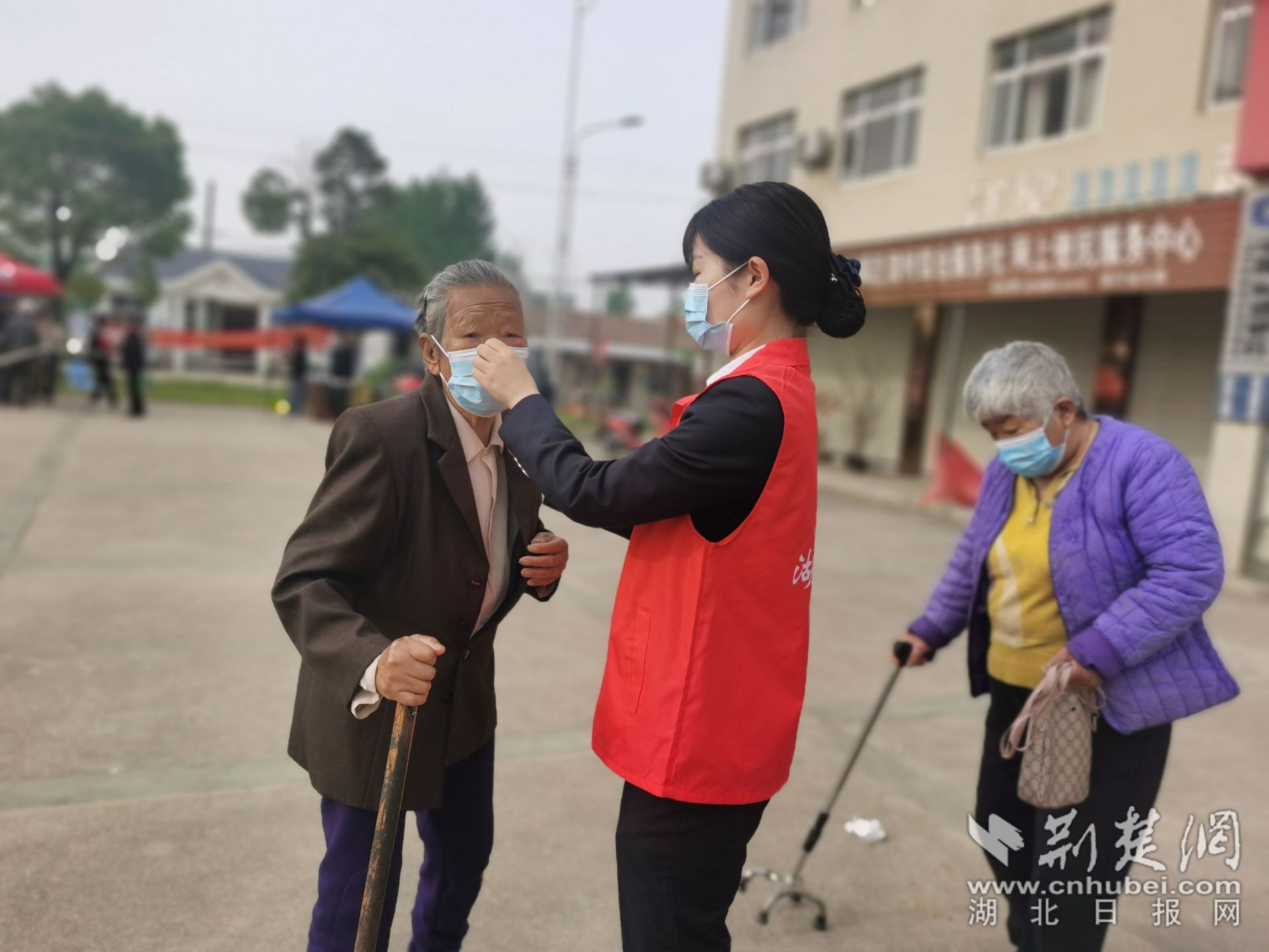 志愿者为老人戴好口罩.jpg.jpg
