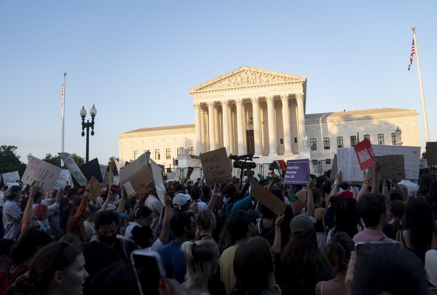 a small group of anti-abortion activists gathered at a street