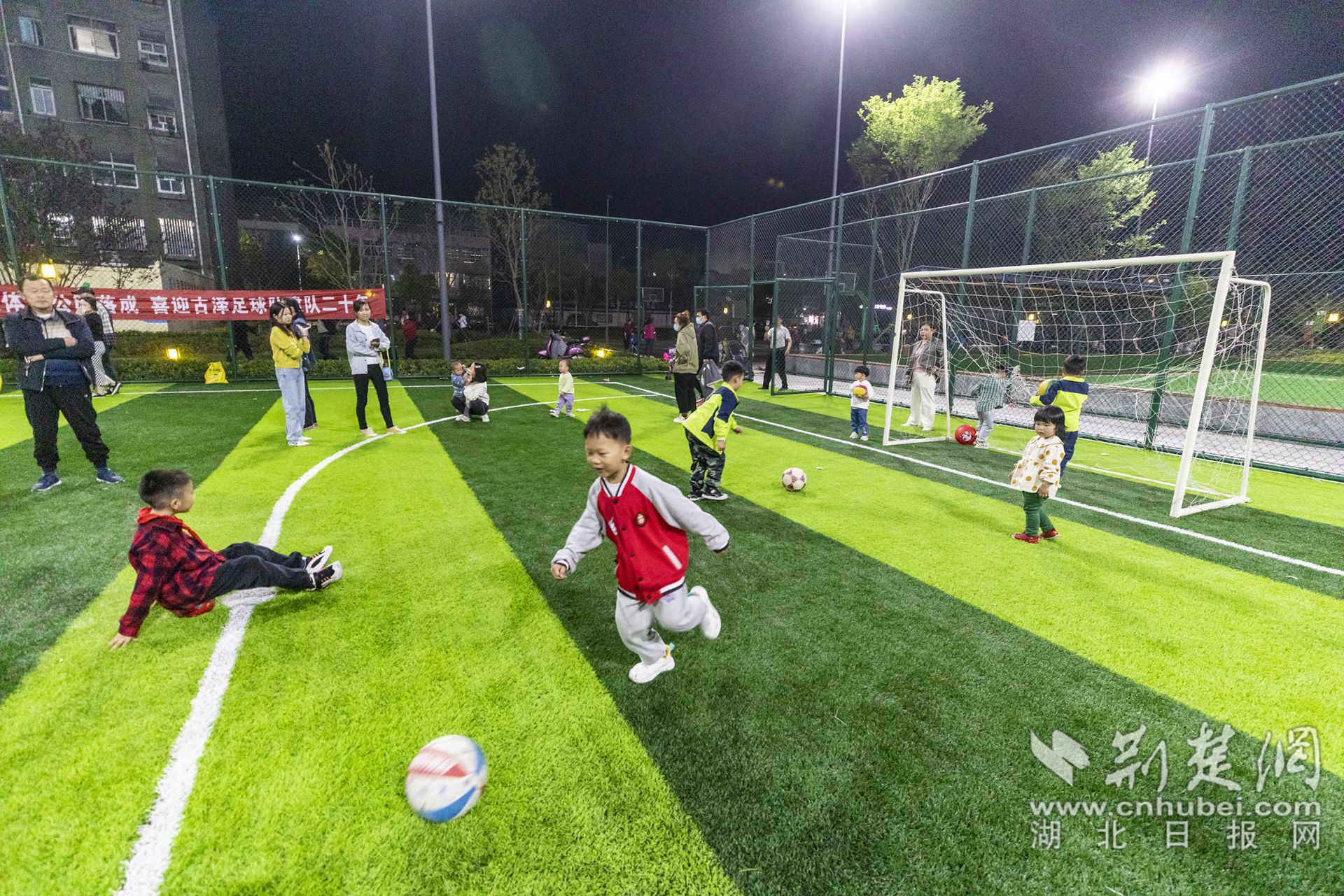孩子们在吴禄贞体育公园足球场上踢球玩耍.jpg.jpg