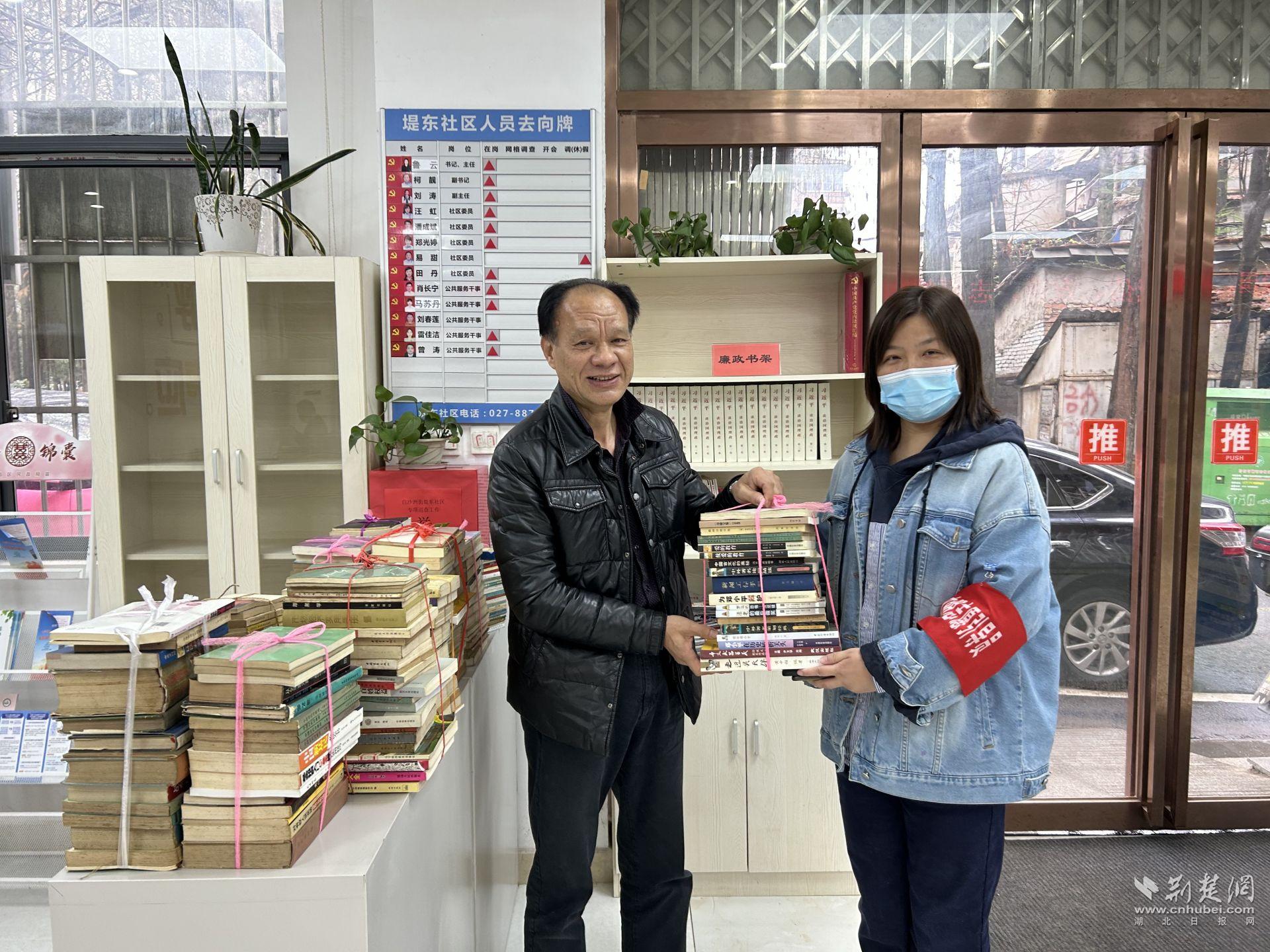 堤东社区党委书记鲁云接受邓良平主任的图书捐赠.jpg.jpg
