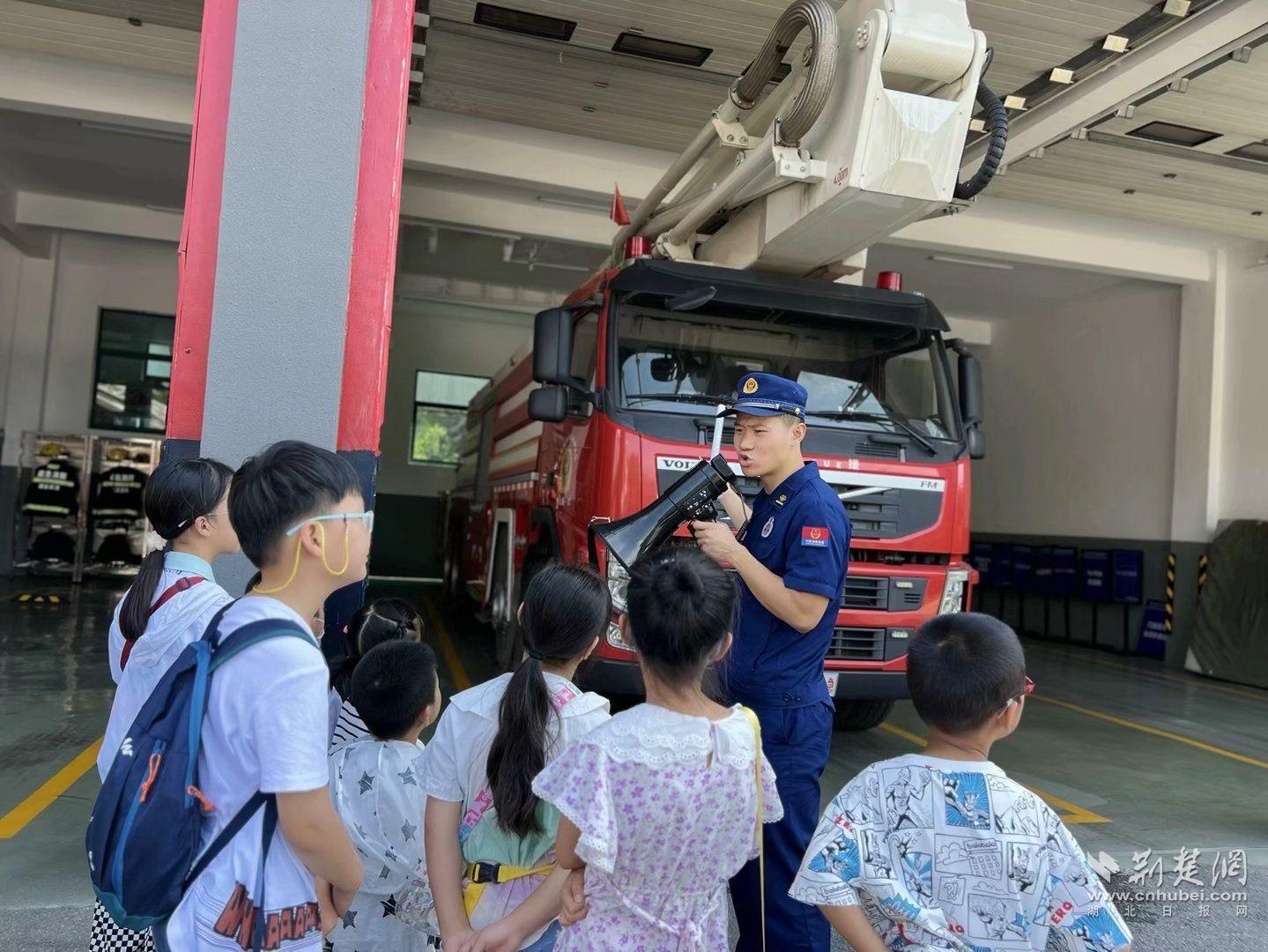 消防员石峻宇向现场青少年讲解消防车.png.png