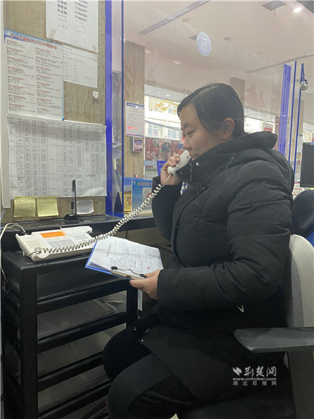 6号窗口工作人提醒指导程阿姨在手机上完成缴费.JPG