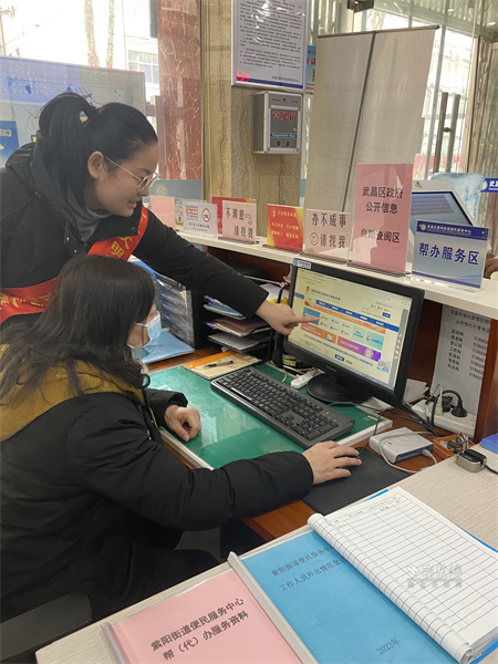 自助查询区的引导员指导高女士在线开具“清税证明”.JPG