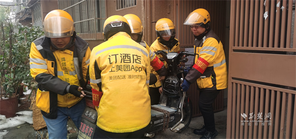 外卖骑手将停放在居民楼内的电动车抬出.jpg