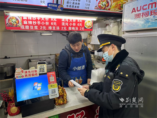 执法队员对商户进行宣传.jpg