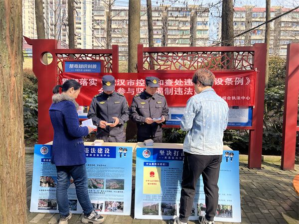 执法人员向社区工作人员进行普法宣传。.jpg.jpg