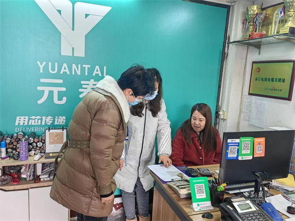 社区工作人员走进商户进行创业补贴政策宣传。.jpg