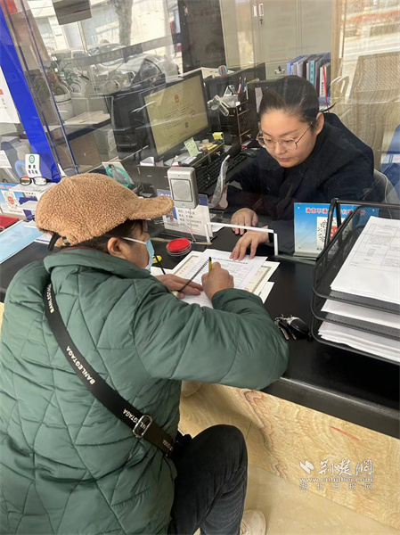 工作人员指导陈女士填写申请资料.jpg