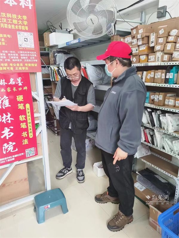 社区工作人员在菜鸟驿站宣传一盔一带安全政策.jpg.jpg