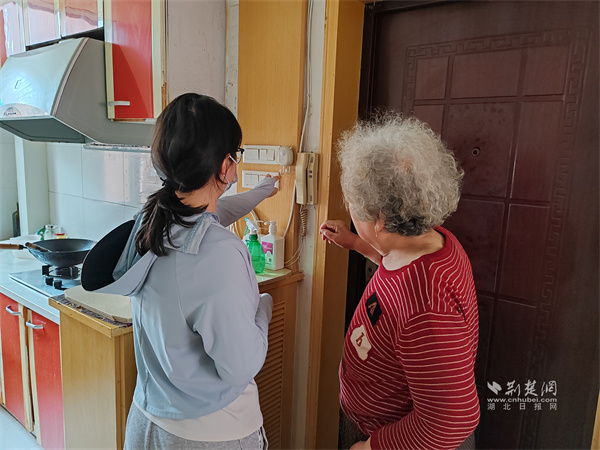 社区网格员为老人安装出门提醒器。.jpg