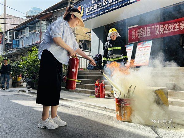 消防员现场指导居民如何使用灭火器.jpg