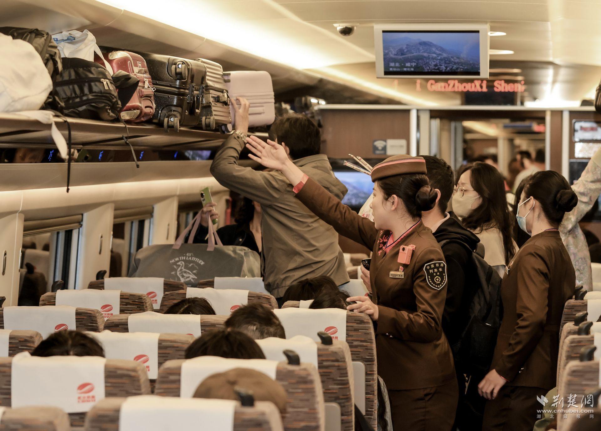 5月1日，武汉客运段G380次列车长孙畅帮助旅客整理行李.jpg.jpg