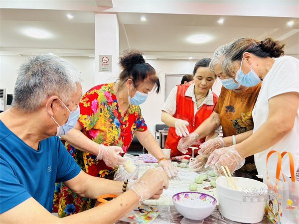 志愿者帮助居民制作月饼。.jpg