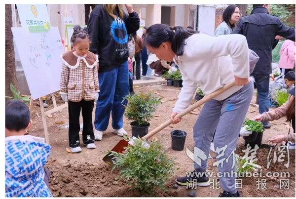 在友友花园中，家长带领小朋友种下自己认领的花卉.jpg