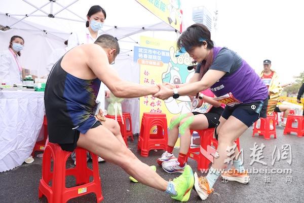 汉马医疗护跑团成员，康复医学科刘亚琼护士长（右一）为全马终点选手进行肌肉拉伸.JPG