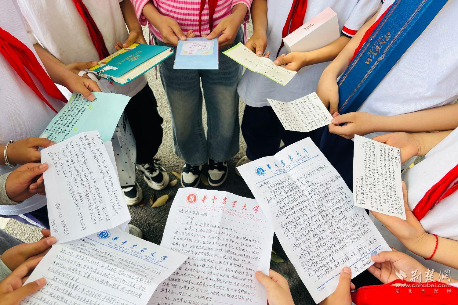 罗家坝小学的孩子们展示华农志愿者书信（通讯员 黄龙倩 摄）.jpg.jpg