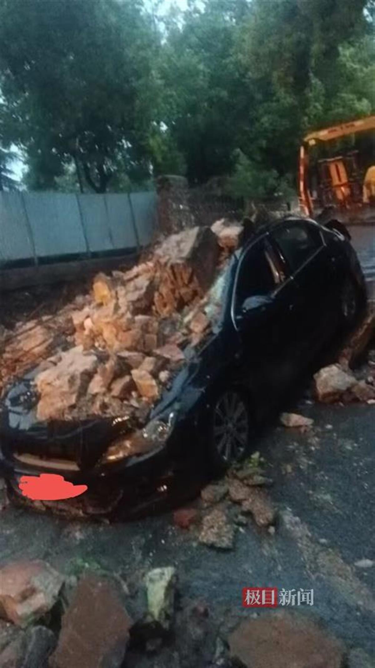 临街的一段院墙在暴雨中忽然崩塌，一辆小车被砸受损