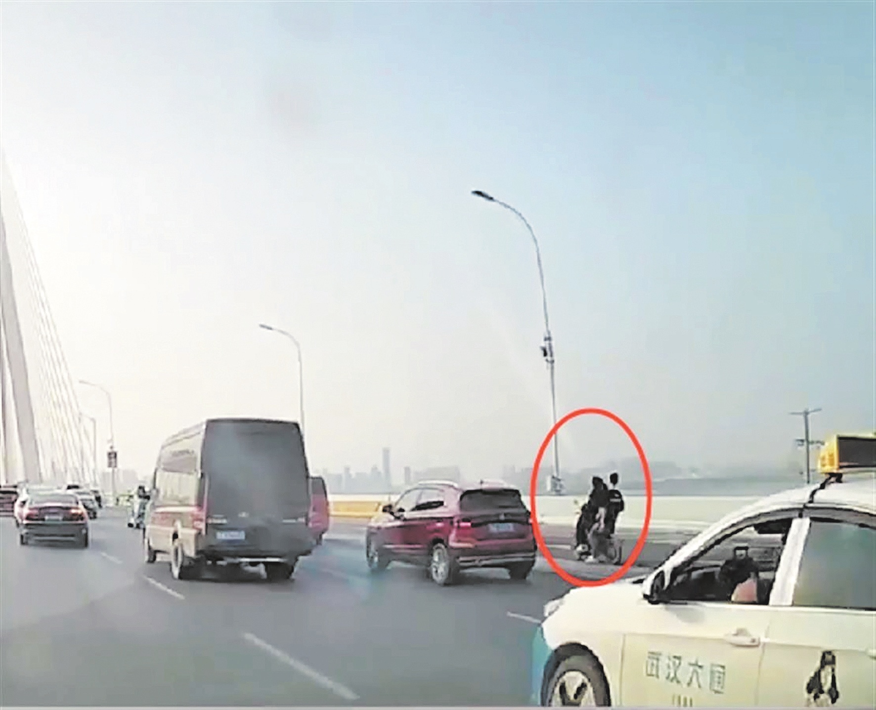 两名年轻人在Erqi长江桥上登上了一辆电动自行车