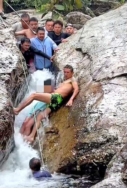 圭村的一个男孩被困在缝隙中，溪流中的巨石。