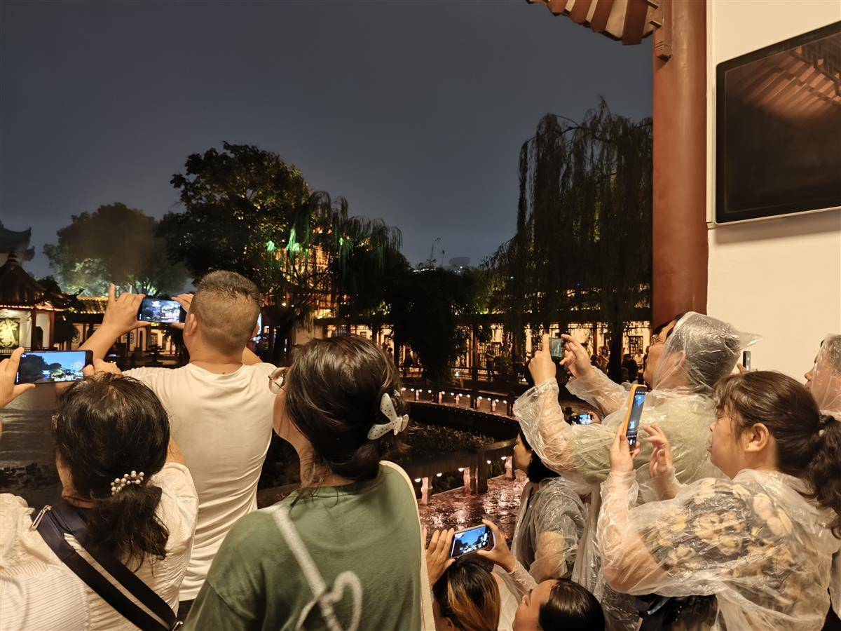 游客在雨中晚上爬上黄色起重机塔，并感谢老师在接受学校开始时的好意