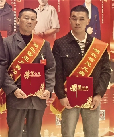 老人在洪水中起身困难。父子俩因辛勤工作而获得国家奖励。