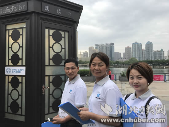 农民工袁健红和工友们在朗读亭外等候.jpg