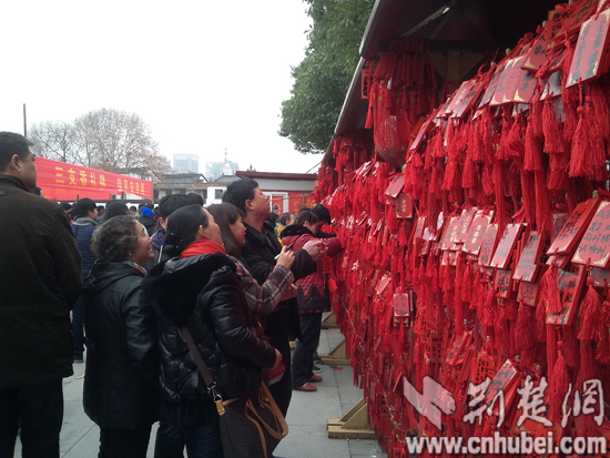 游客在归元禅寺祈福墙前挂许愿牌祈福平安.