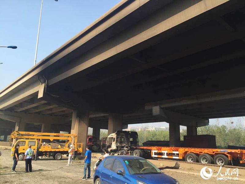 爆炸点附近的轻轨干道已烧黑,支桥下的卡车也被炸毁。人民网记者潘旭海 摄