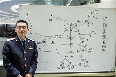 调度员张博站在他绘制的“中国高铁路网图”前。新华社发