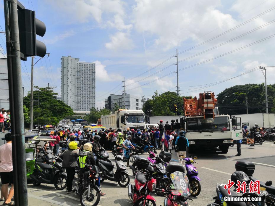 菲律宾马尼拉一骑手十字路口卷入卡车下造成交通拥堵