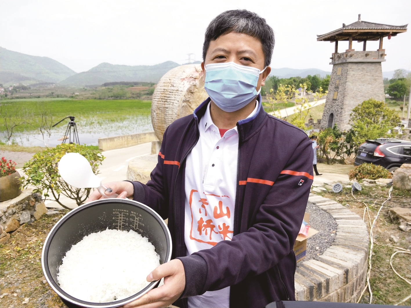 魏明超在田边展示他煮出的米饭□楚天都市报记者 高伟 通讯员 李慧敏