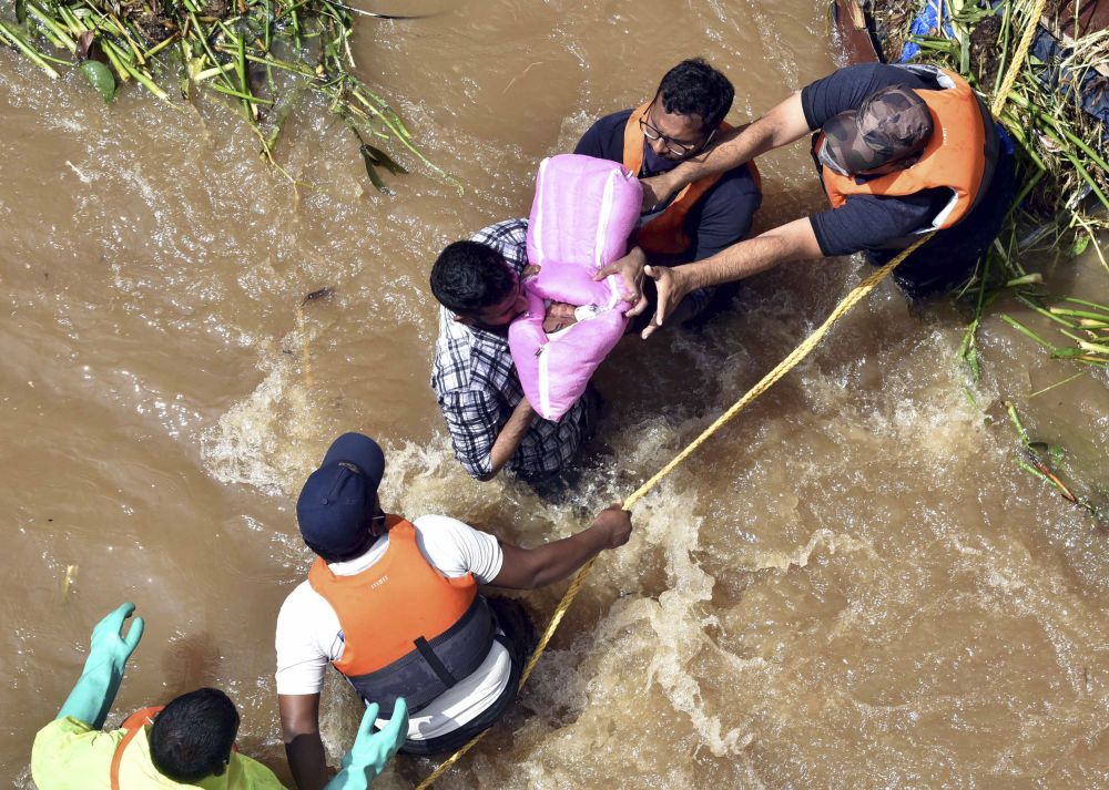10月18日,救援人员从印度海得拉巴一处被洪水围困的房屋中救出一名