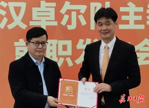 武汉卓尔职业足球俱乐部董事长田旭东(左)向李霄鹏颁发聘书.