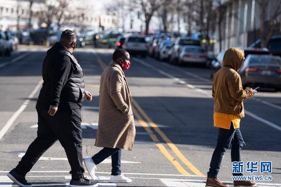 1月18日,在美国华盛顿,戴口罩的行人从国会大厦附近走过.