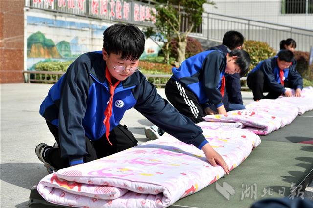 4月27日,保康县城关镇小学学生在进行叠被子比赛.