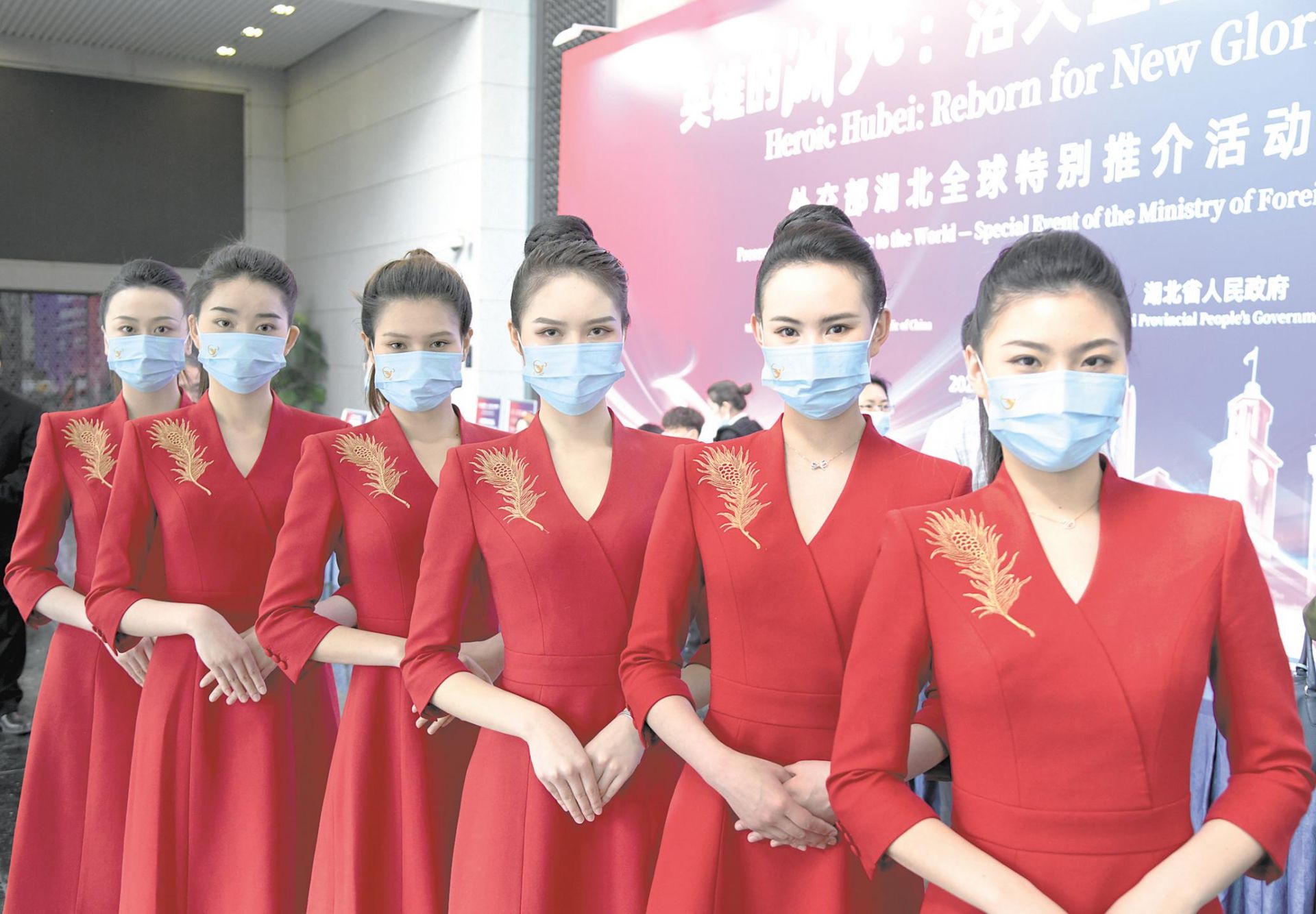 外交部湖北全球特别推介活动现场,身着特色红礼服的迎宾员.