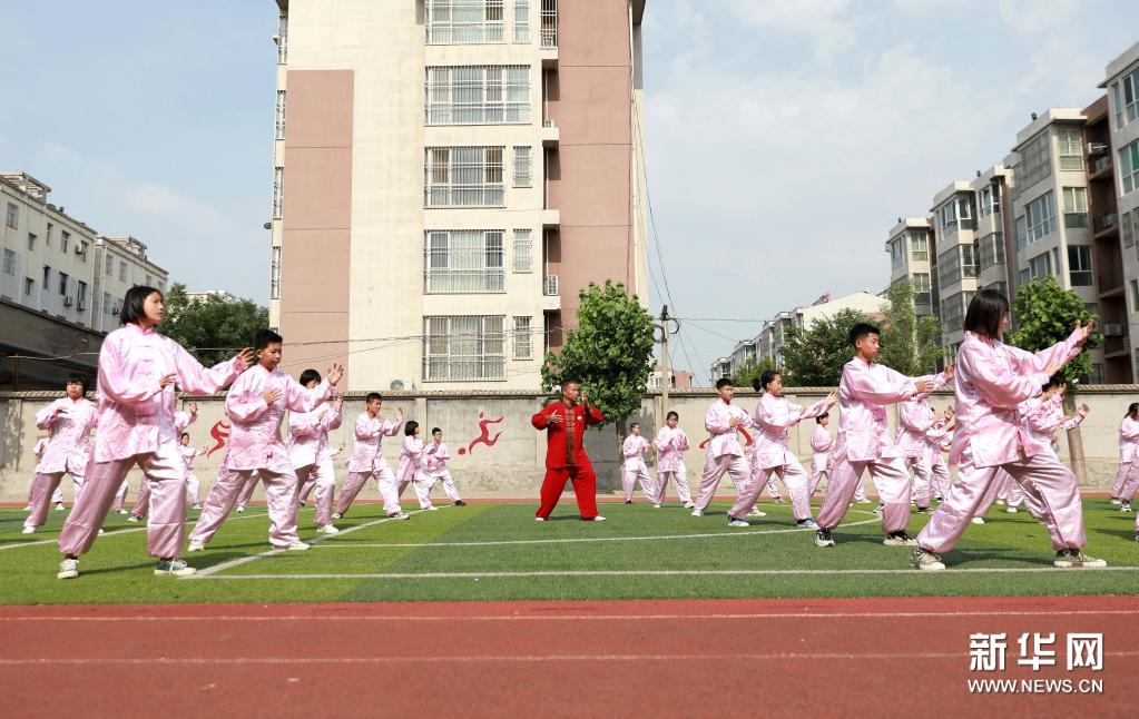 6月7日,在河北省邢臺市任澤區第三中學,太極拳教練指導學生進行練習.