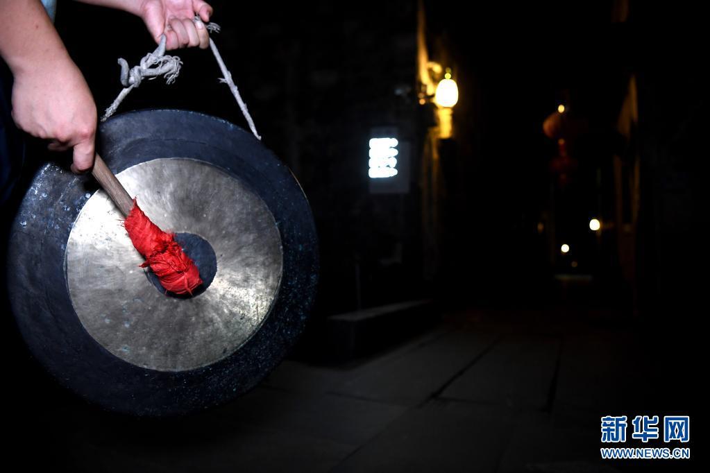 7月29日深夜,卢磊在西递村的街巷里打更.新华社记者 韩旭 摄