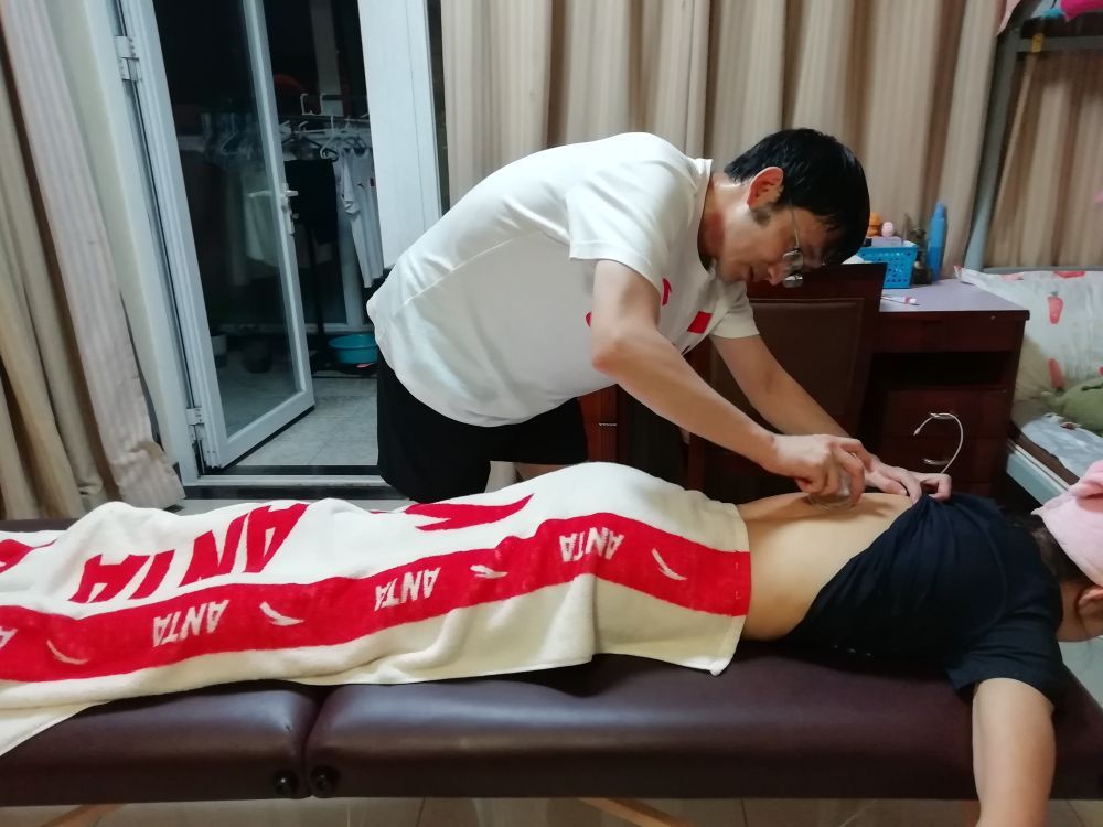 (↑队医廖远朋为运动员按摩治疗)