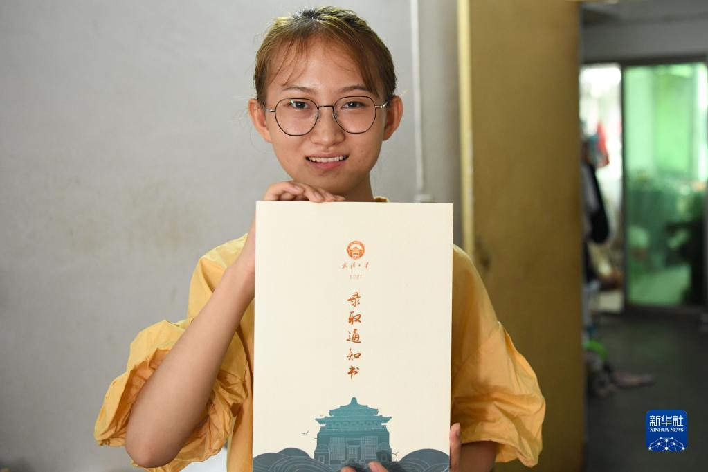 8月28日,欧阳程程在安庆市租住的房子里展示武汉大学录取通知书